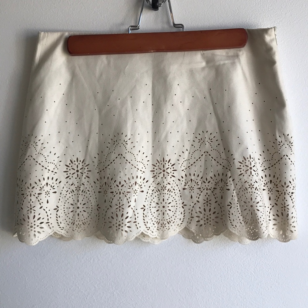 Cream mini skirt with cutouts. Size small.
